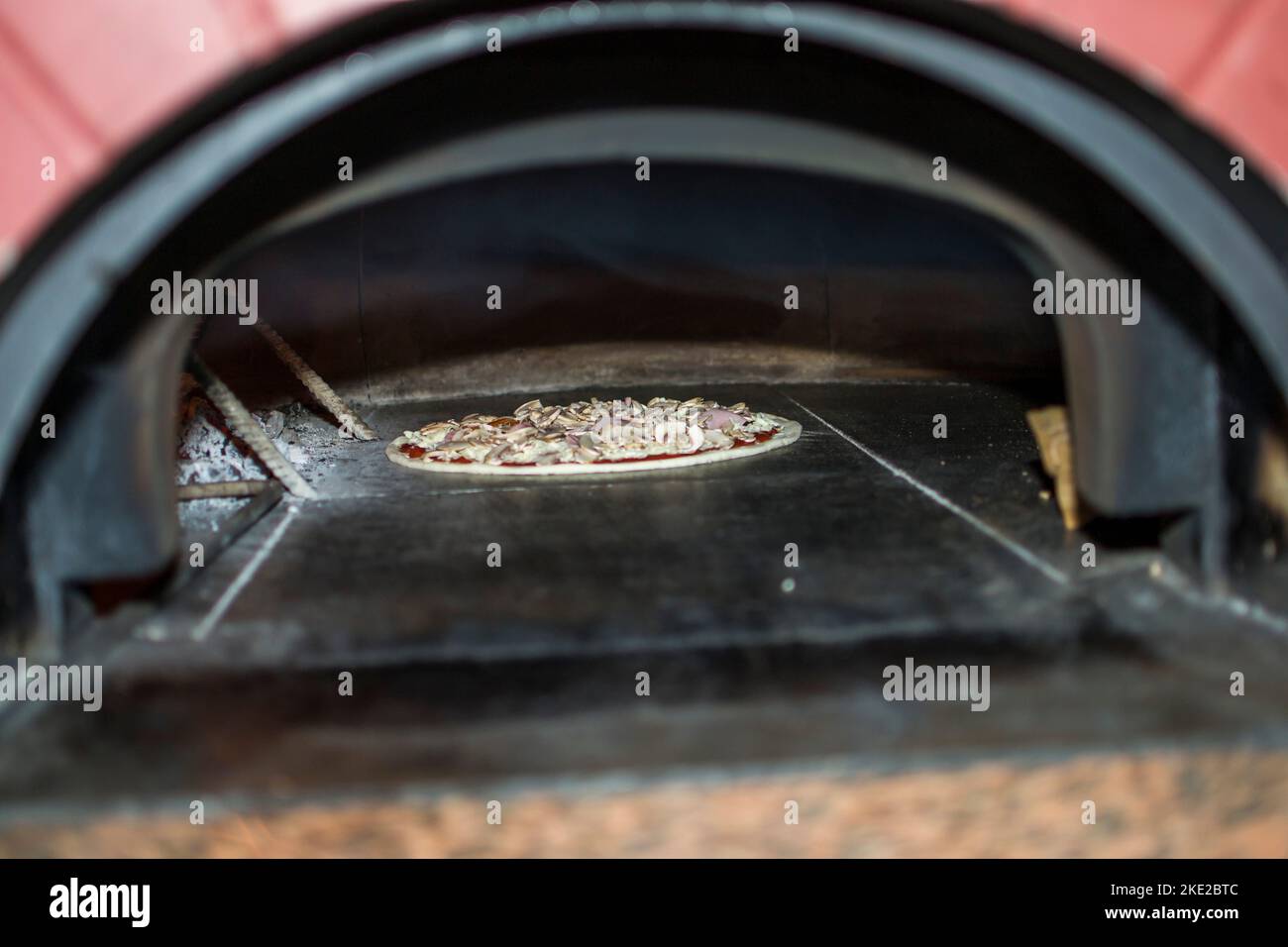 cooking pizza in the oven . Pizza near the stone stove with fire. Background of a traditional