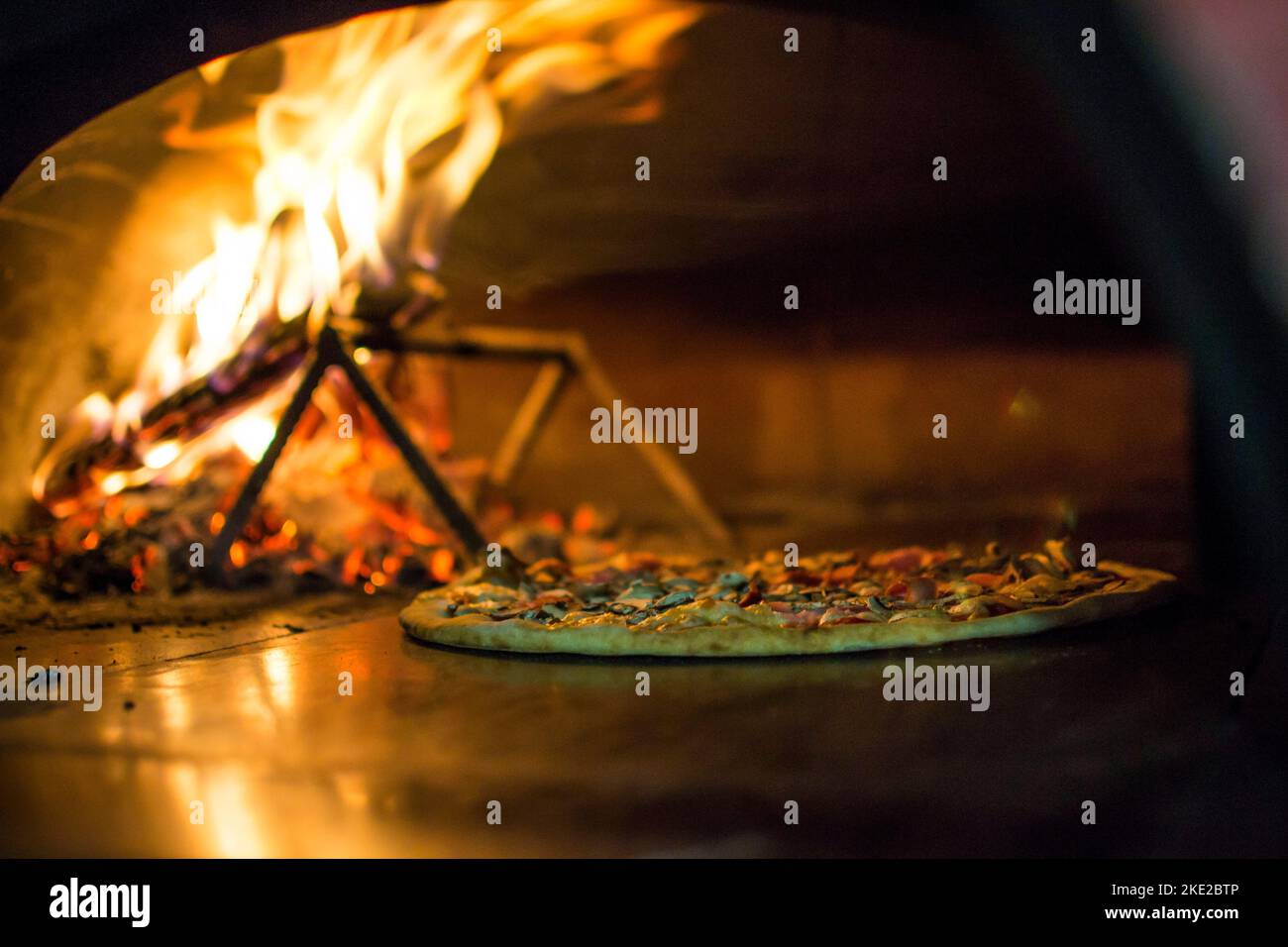 cooking pizza in the oven . Pizza near the stone stove with fire. Background of a traditional