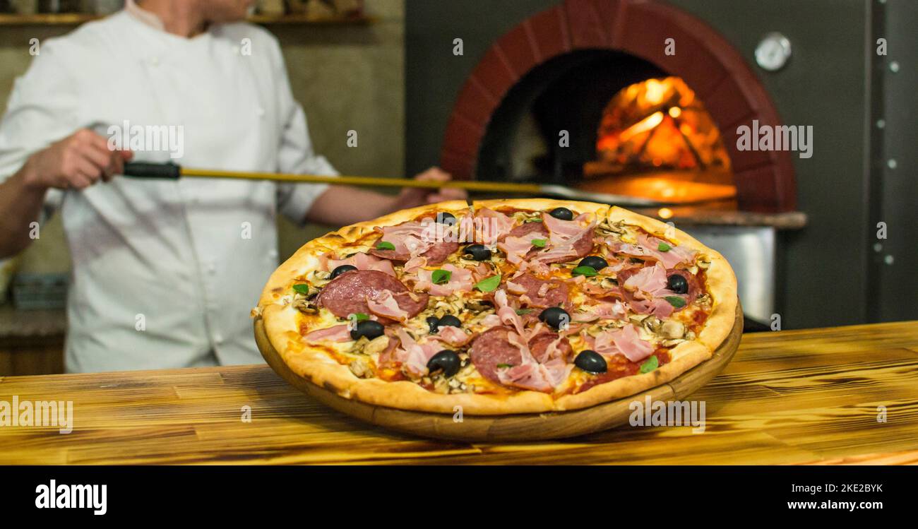 cooking pizza in the oven . Pizza near the stone stove with fire