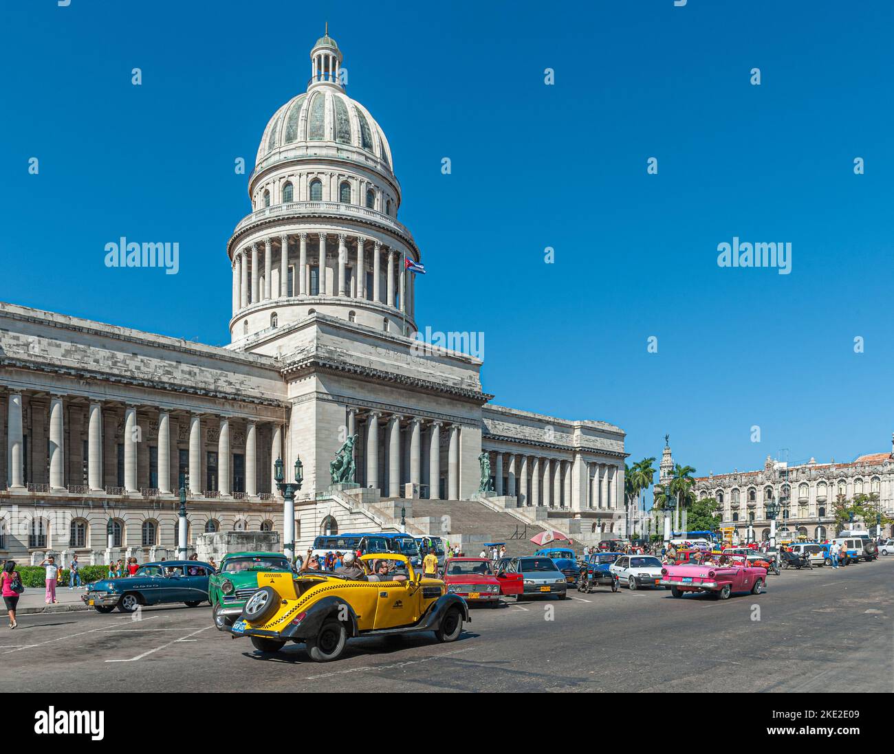 Capitol building in Havana Cuba with old American cars driving past Stock Photo