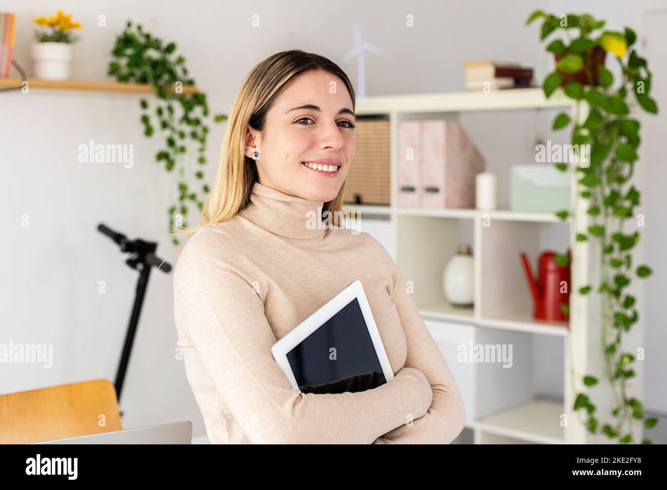 Happy young business woman holding digital tablet standing in office studio Stock Photo
