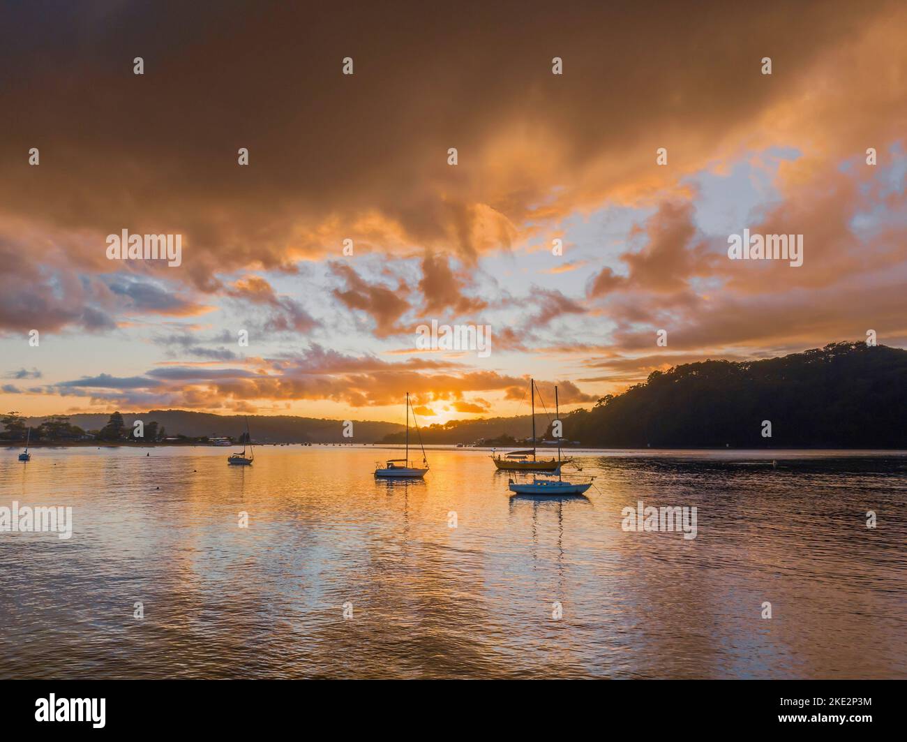 Rain clouds and sunrise over the channel in Ettalong Beach on the Central Coast, NSW, Australia. Stock Photo