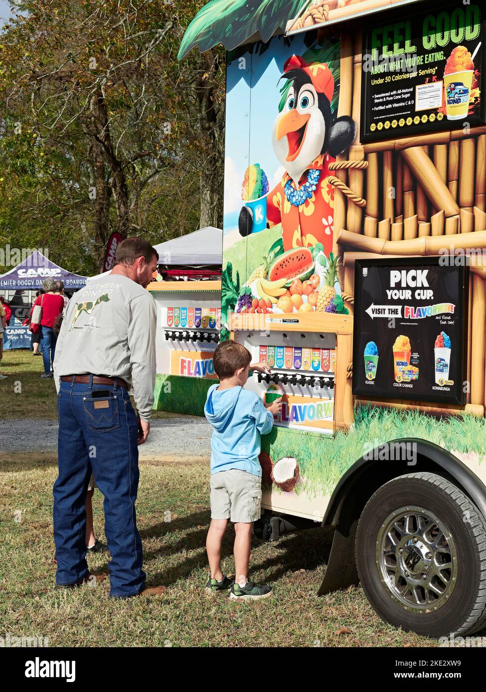 Father and son buying and fixing snow cones at the Kona Ice truck at a family arts and crafts fair in Pike Road Alabama, USA. Stock Photo