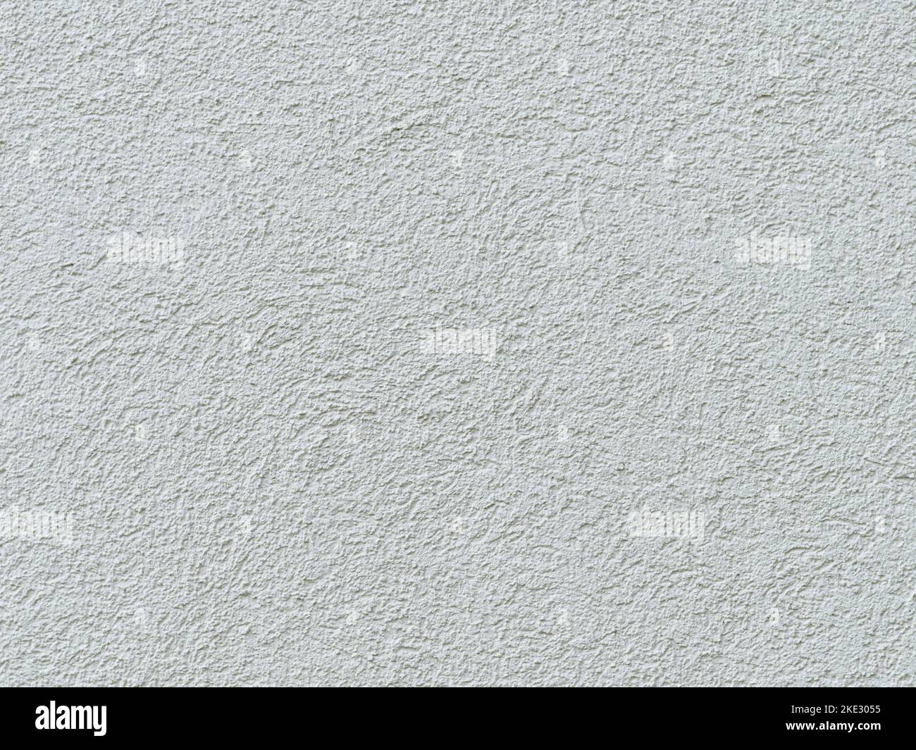 White wall plaster on a house facade. Full frame background texture of a building exterior in Germany. The structure is clean and modern. Stock Photo