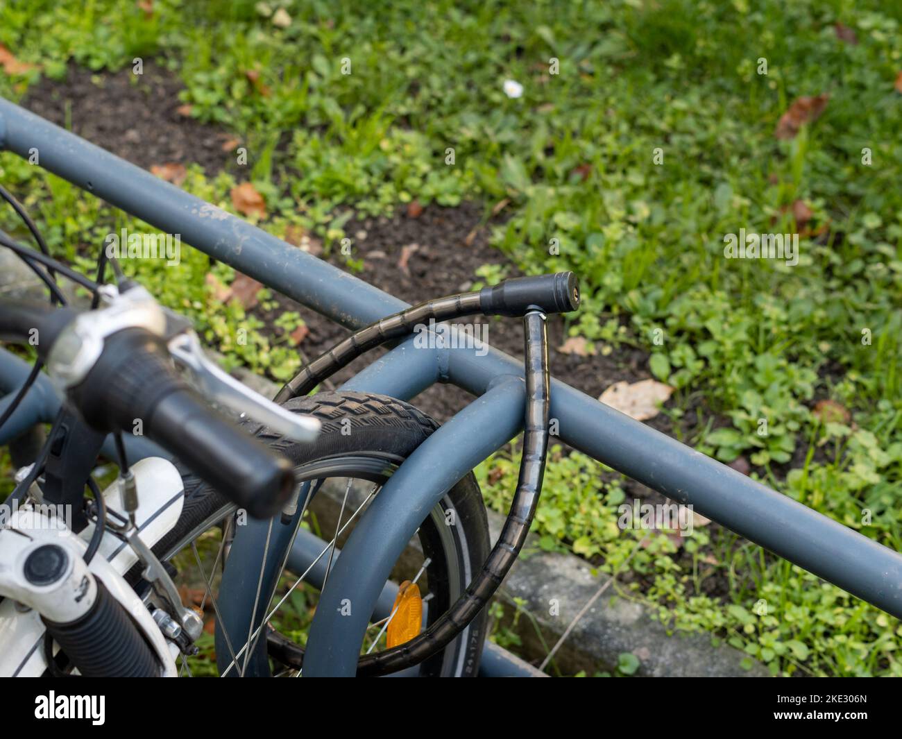 Bicycle lock through the front wheel. The lock is closed and protecting the bike from theft. The prevention is very weak if the wheel is removed. Stock Photo