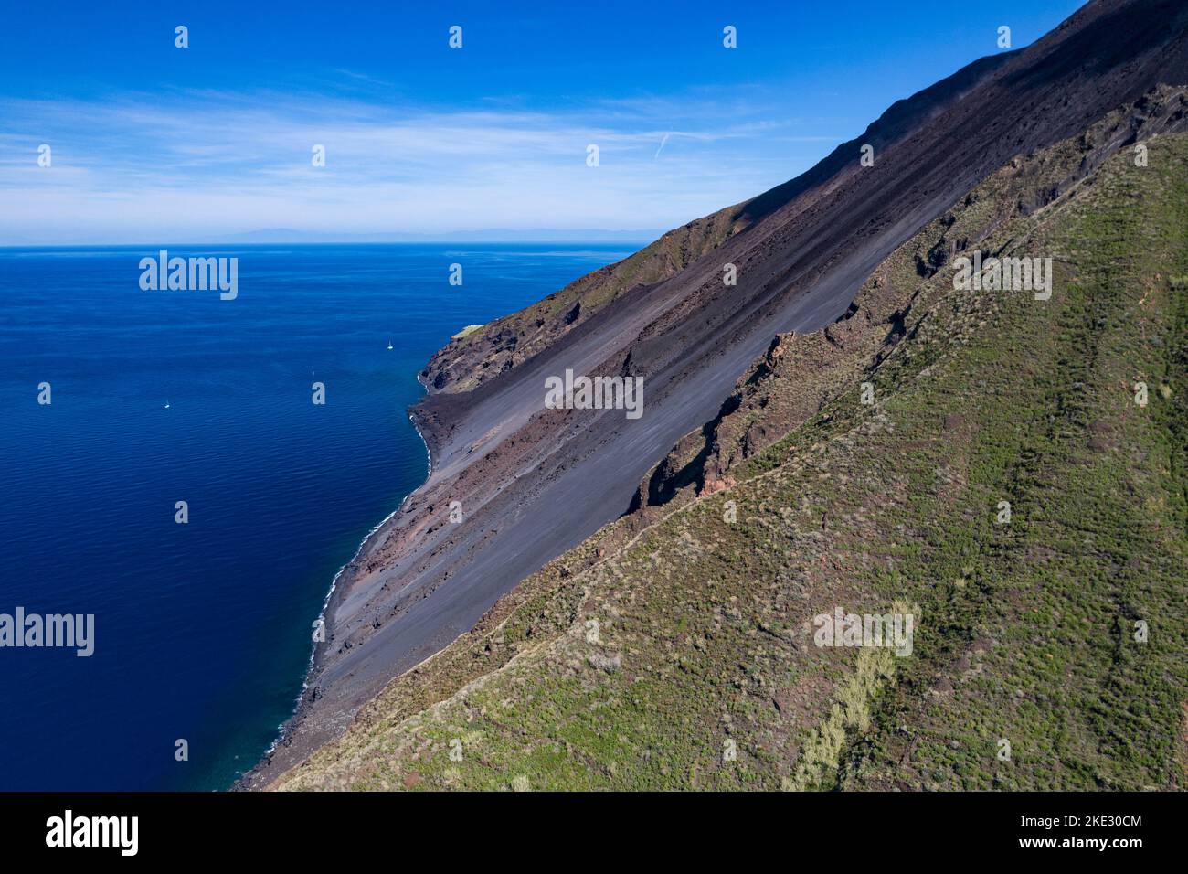The stromboli vulcano erupting on the 'Sciara del Fuoco' north west side, day shot, blue sky background, panoramic shot, eolians islands, sicily,  Ita Stock Photo