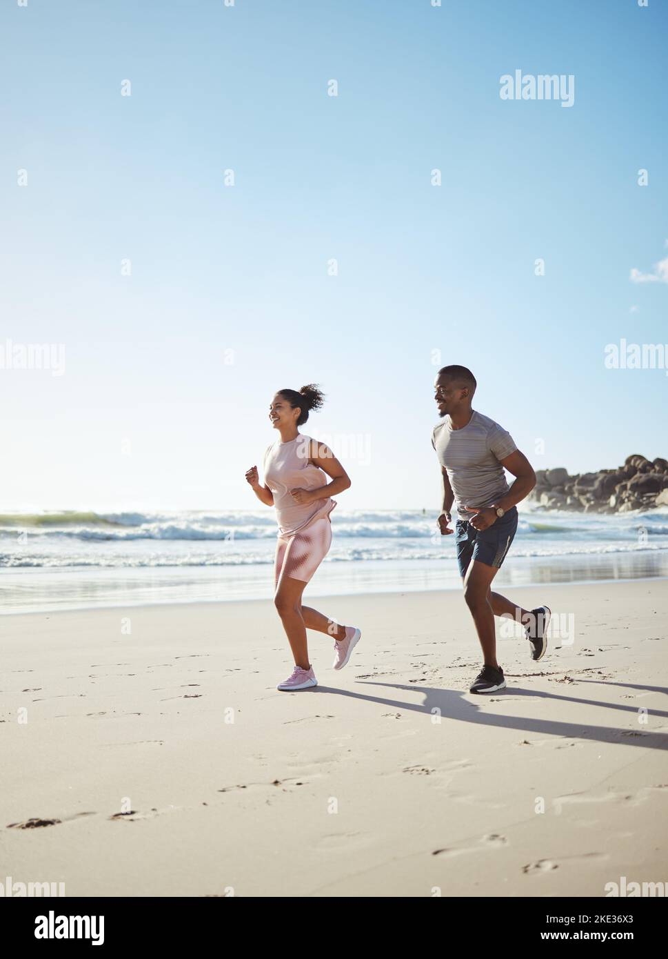 Beach, couple running and cardio fitness training or wellness challenge together. Friends, sports teamwork run and healthy runner lifestyle motivation Stock Photo