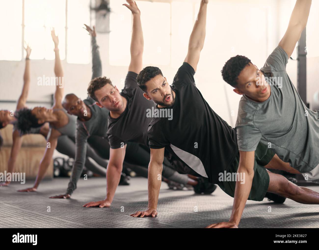 Teamwork, fitness or sport team stretching in gym, studio or arena floor for wellness, exercise or sports workout. Diversity, health or athlete group Stock Photo