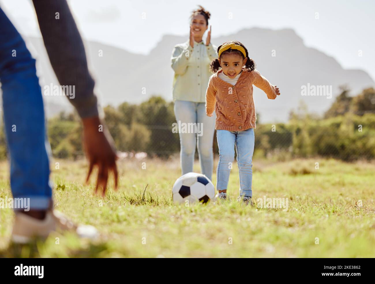 Parents, park and girl kick soccer ball for fun sports learning