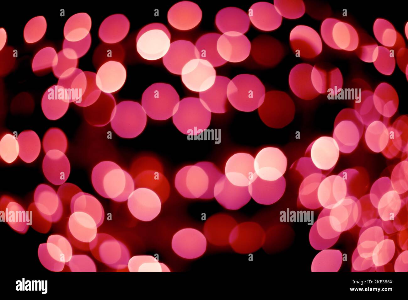 Defocused christmas red abstract bokeh lights background. Festive lights. Blurred holiday bokeh. Stock Photo