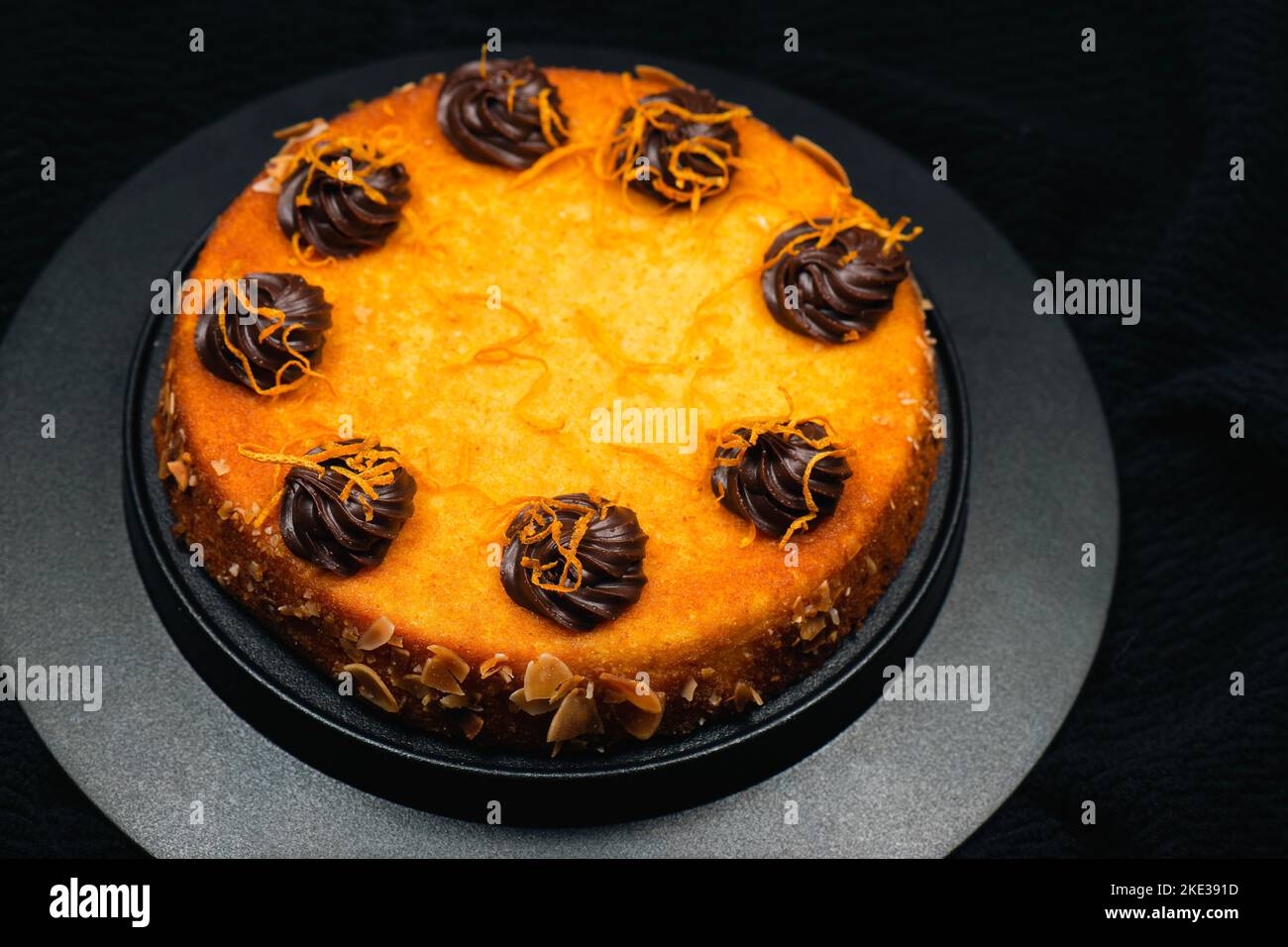 Orange flourless cake with zest, flaked almonds, and chocolate ganache