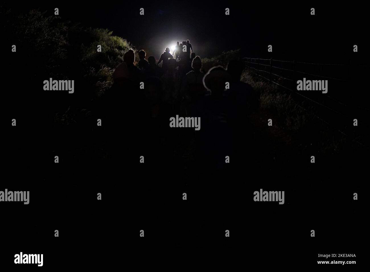 Asylum seeking migrants from Central America are followed by a border patrol vehicle as they walk along a fence line after being smuggled across the Rio Grande river from Mexico into Roma, Texas, U.S., November 9, 2022.  REUTERS/Adrees Latif Stock Photo