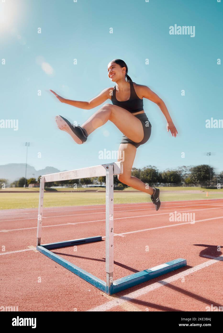 Fitness, hurdle and woman running in stadium track for training, health