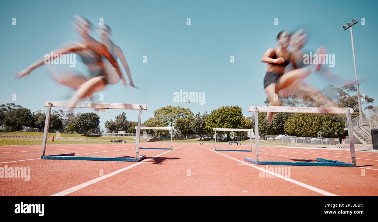 Fitness, jump or running women in a hurdles sports competition or athletes racing event with speed. Training, exercise and fast girl sprinters jumping Stock Photo