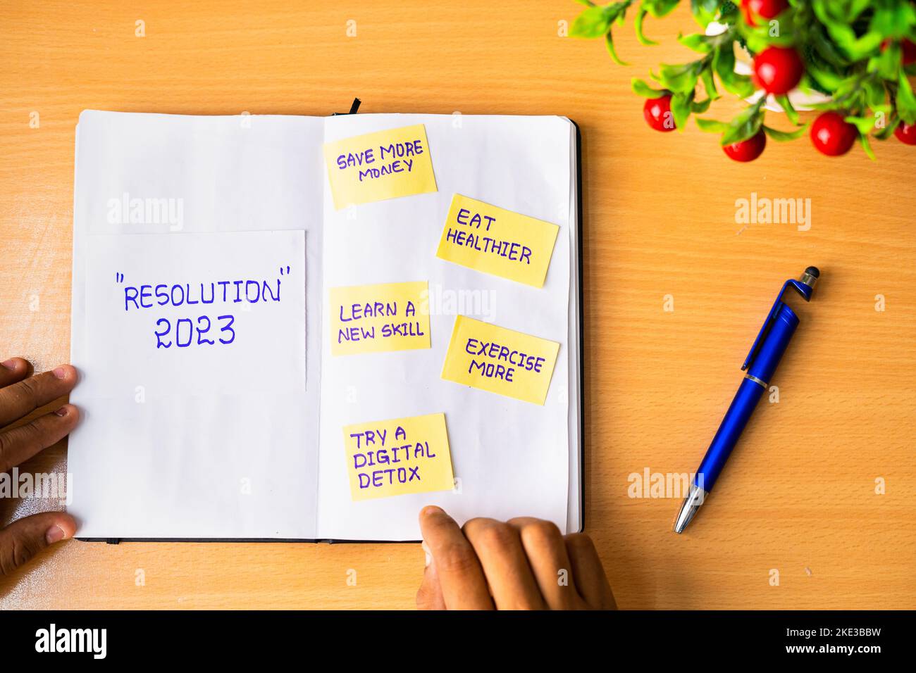 close up of hands adding making note of new year 2023 resolutions on dairy - concept of personal improvement or development and aspiration Stock Photo