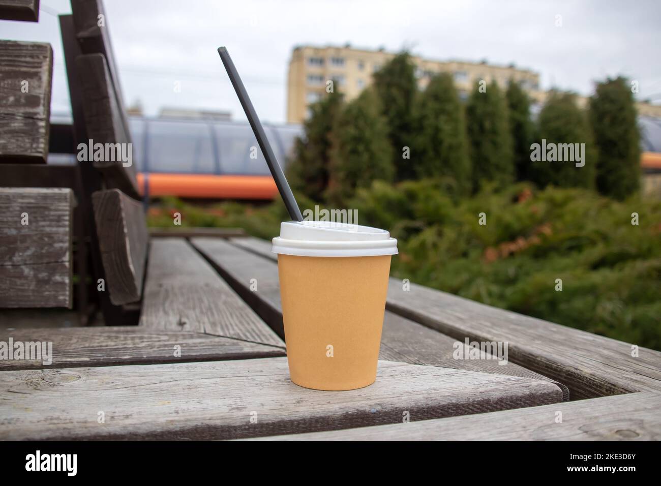 Paper glass with drink on a wooden bench close up Stock Photo