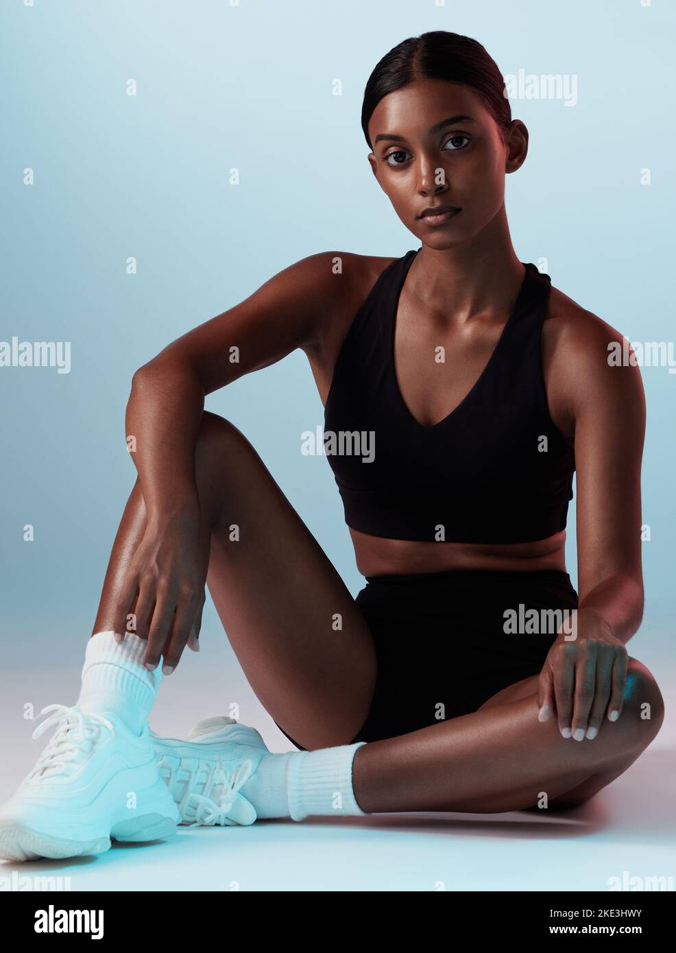 Woman, fitness or posing on blue background in studio in gym clothes