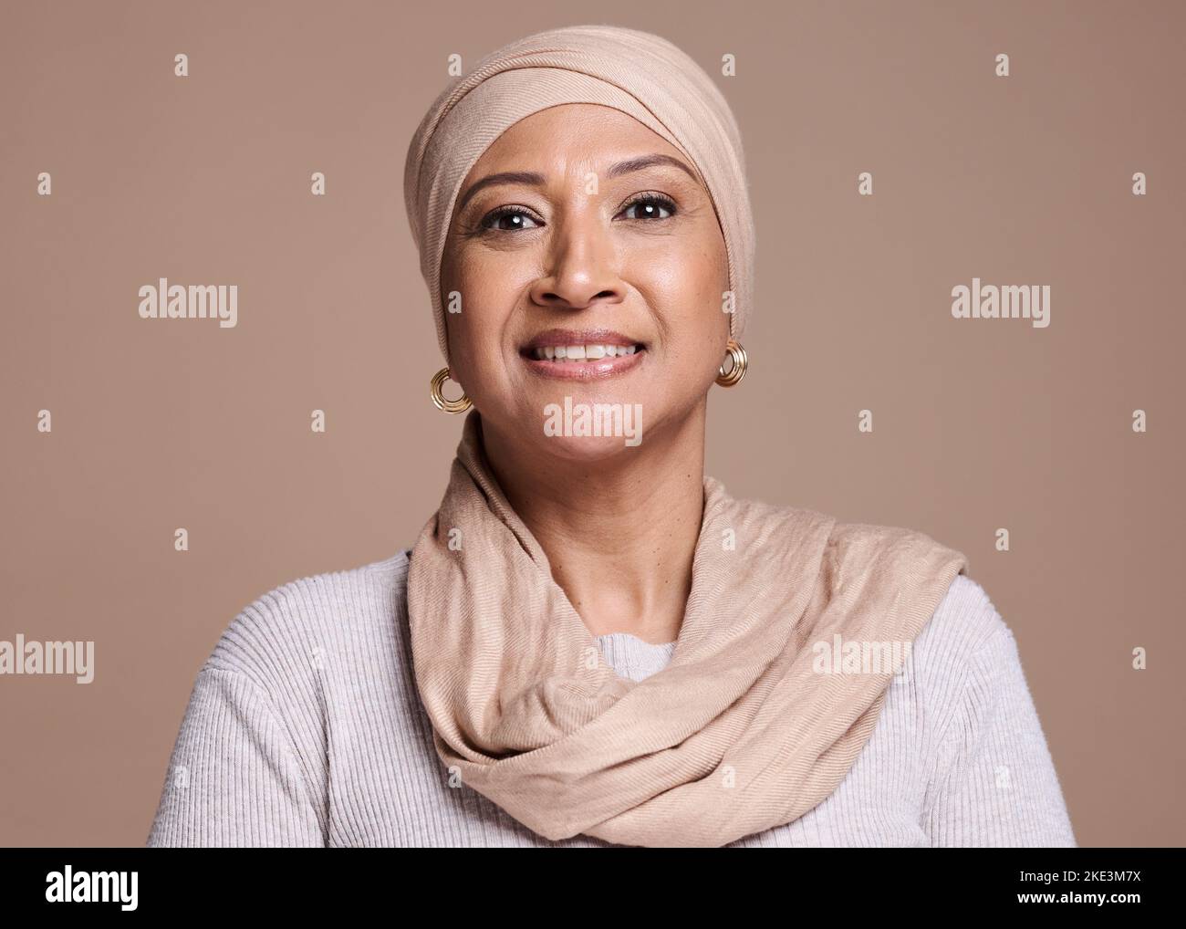 Muslim, hijab and arab ,woman in studio for beauty, religion and happiness for cosmetics, makeup and fashion on a brown background. Face portrait of a Stock Photo