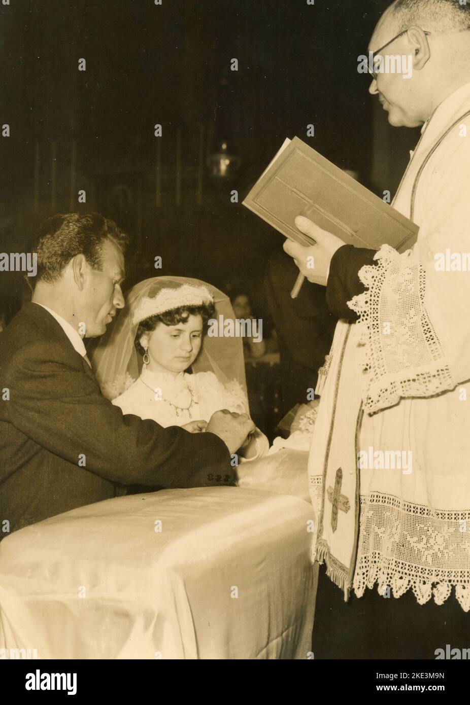 Wedding in a village in central Italy: The Bride and the Groom in the church in front of the priest, 1950s Stock Photo