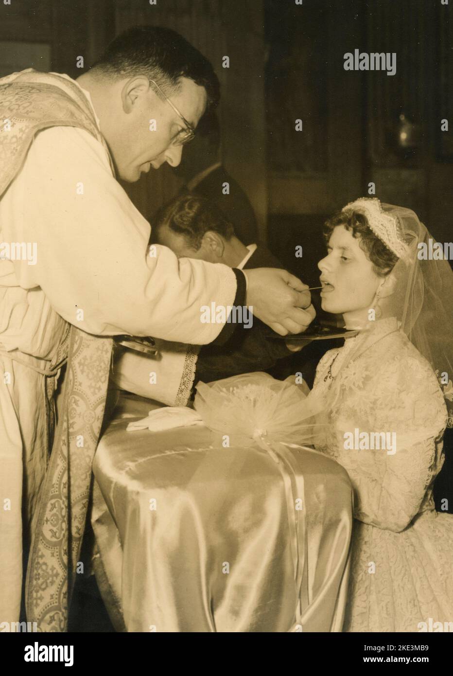 Wedding in a village in central Italy: The Bride in the church takes the communion, 1950s Stock Photo