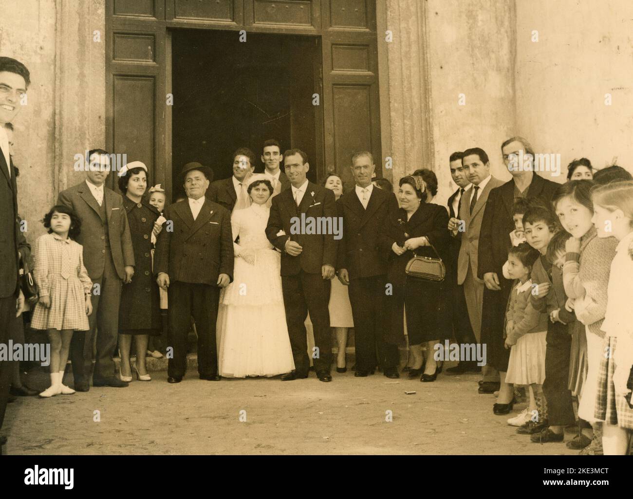 Wedding in a village in central Italy: The Bride and the Groom just married out of the church with friends and relatives, 1950s Stock Photo