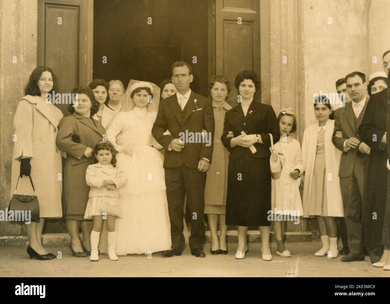 Wedding in a village in central Italy: The Bride and the Groom just married out of the church with friends and relatives, 1950s Stock Photo