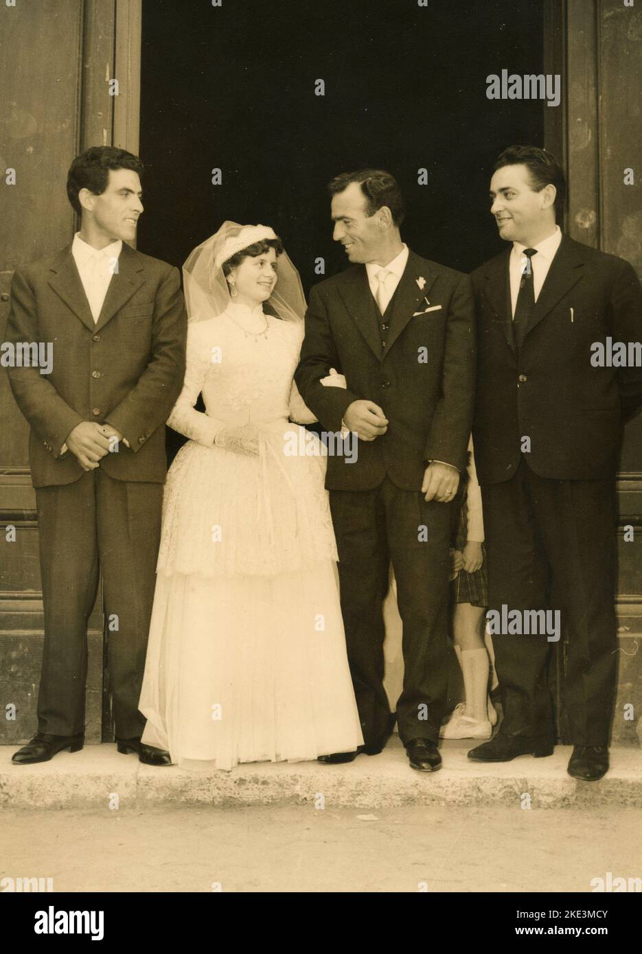 Wedding in a village in central Italy: The Bride and the Groom just married out of the church with the best men, 1950s Stock Photo