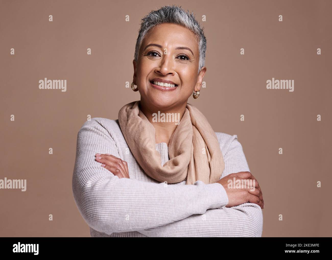 Face, fashion and style with a senior woman in studio on a brown background to model contemporary clothes. Portrait, fashionable and stylish with a Stock Photo