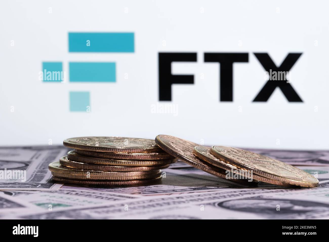 FTX Cryptocurrency Exchange bankruptcy concept. FTX logo seen on display, and stack of fallen bitcoin tokens. Stafford, United Kindom, November 10, 20 Stock Photo