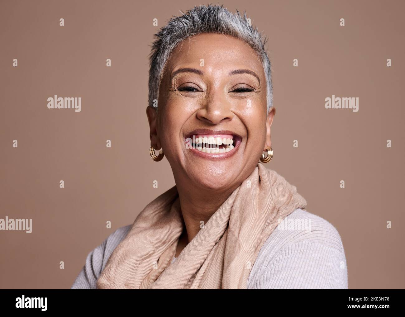 Mature woman, face and laughing on studio background in fashion, trendy or style clothes and makeup cosmetics. Portrait, smile or happy model with Stock Photo