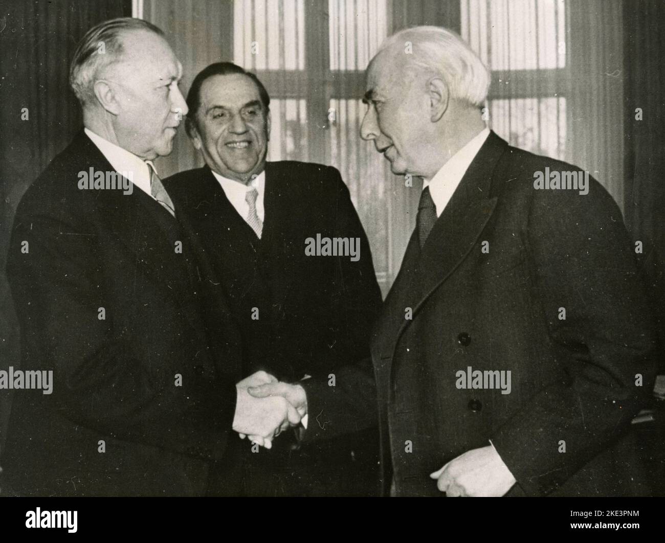 West German President Theodor Heuss (right) shake hands with Federal Chancellor Konrad Adenauer (left), in the middle Wilhelm Niklas, Berlin 1950 Stock Photo