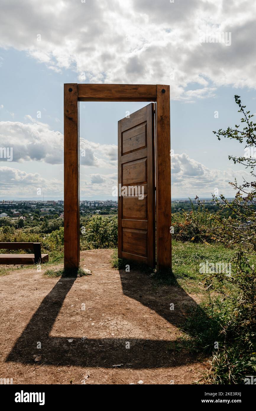 An open wooden door with a view of the city, the door stands in the
