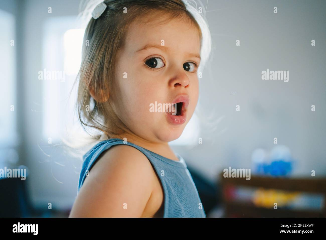 The portrait of a girl who just woke up, yawning and looking at the camera. Family concept. Closeup portrait. People emotion portrait concept. Stock Photo