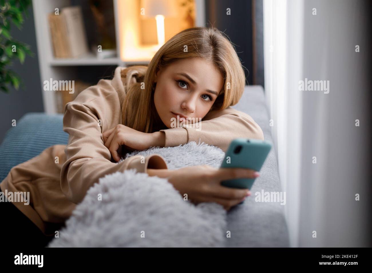 Blonde woman using phone home hi-res stock photography and images - Alamy