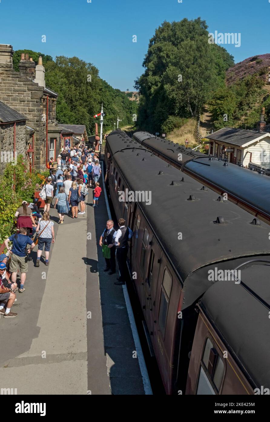 People tourists visitors on Goathland steam train station platform in summer North Yorkshire Moors Railway near Whitby North Yorkshire England UK Stock Photo