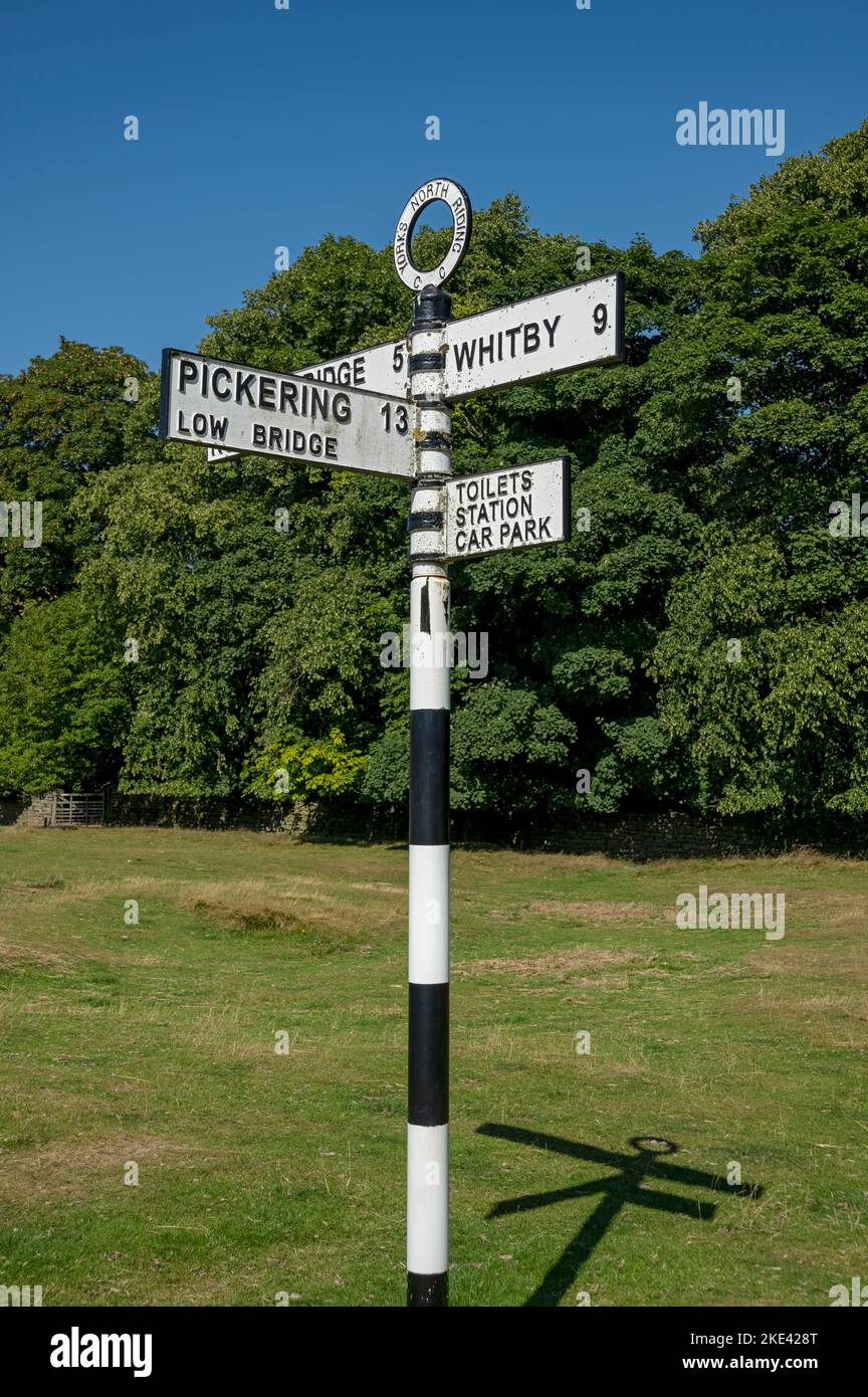 Old metal road sign post showing directions to Whitby and Pickering in summer Goathland North Yorkshire England UK United Kingdom GB Great Britain Stock Photo
