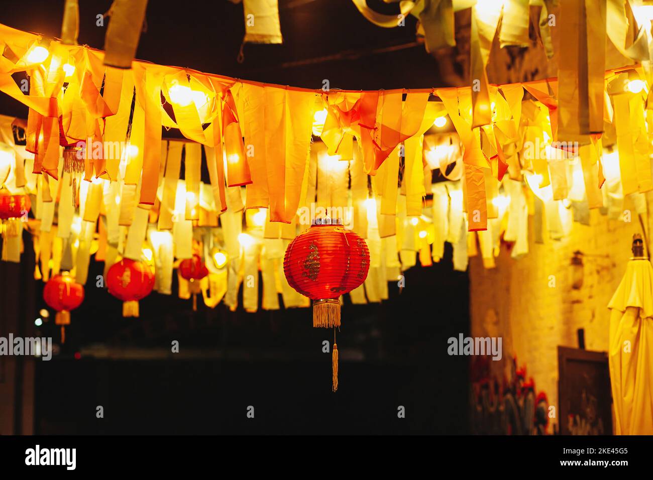 Chinese paper red lanterns hang with garlands of ribbons and lamps