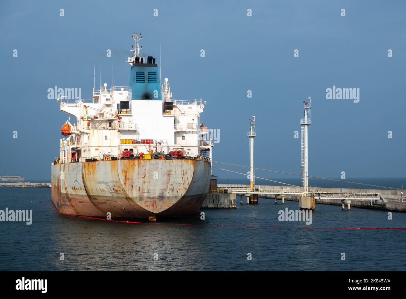 Tanker moored in the port for the duration of the crude oil unloading operation. Photo taken in natural lighting conditions. Stock Photo