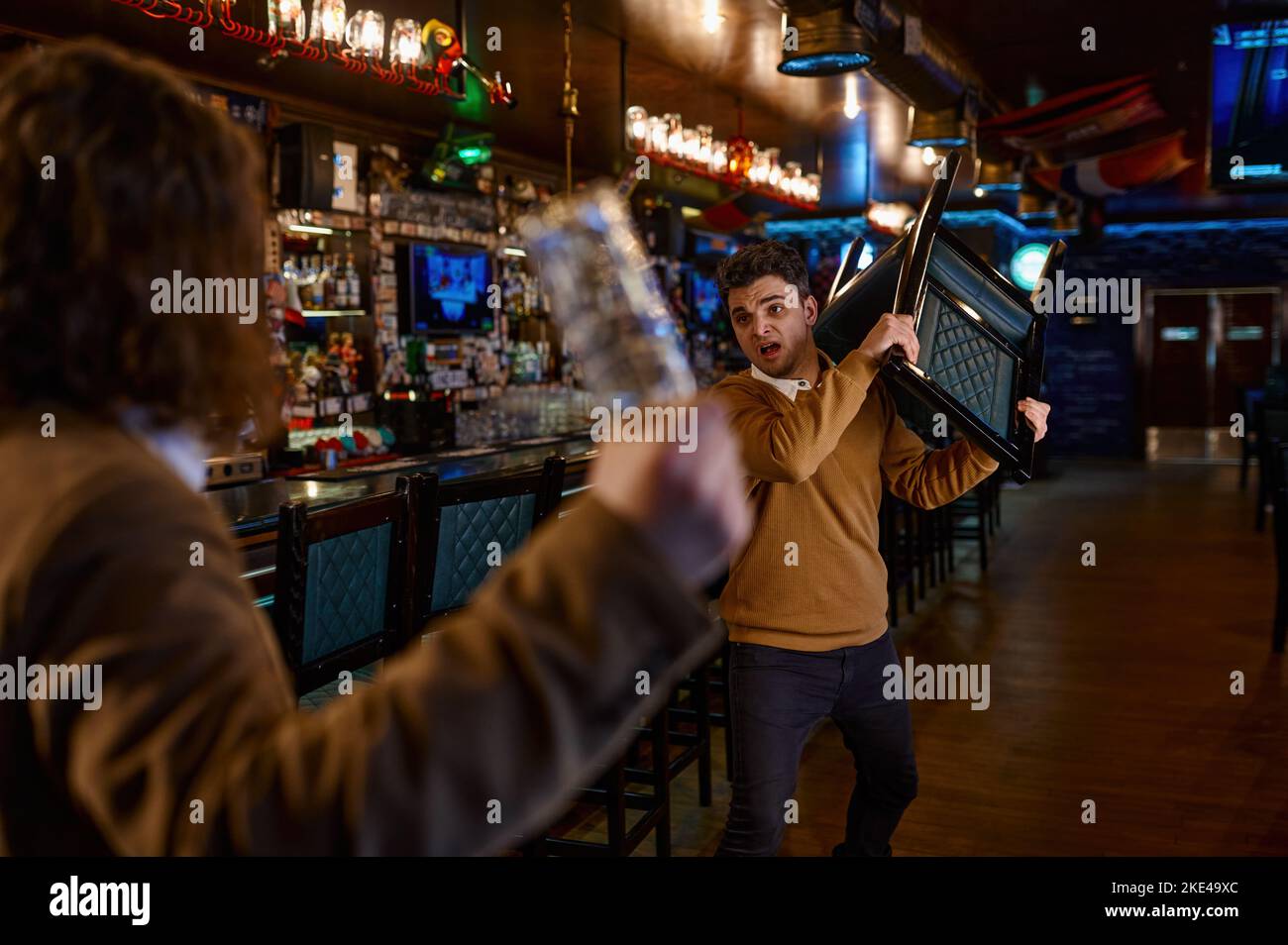 Two man hooligan football fans get in bar fight Stock Photo