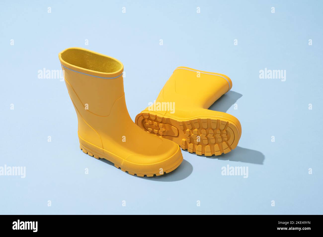 Yellow rubber boots isolated on blue background Stock Photo