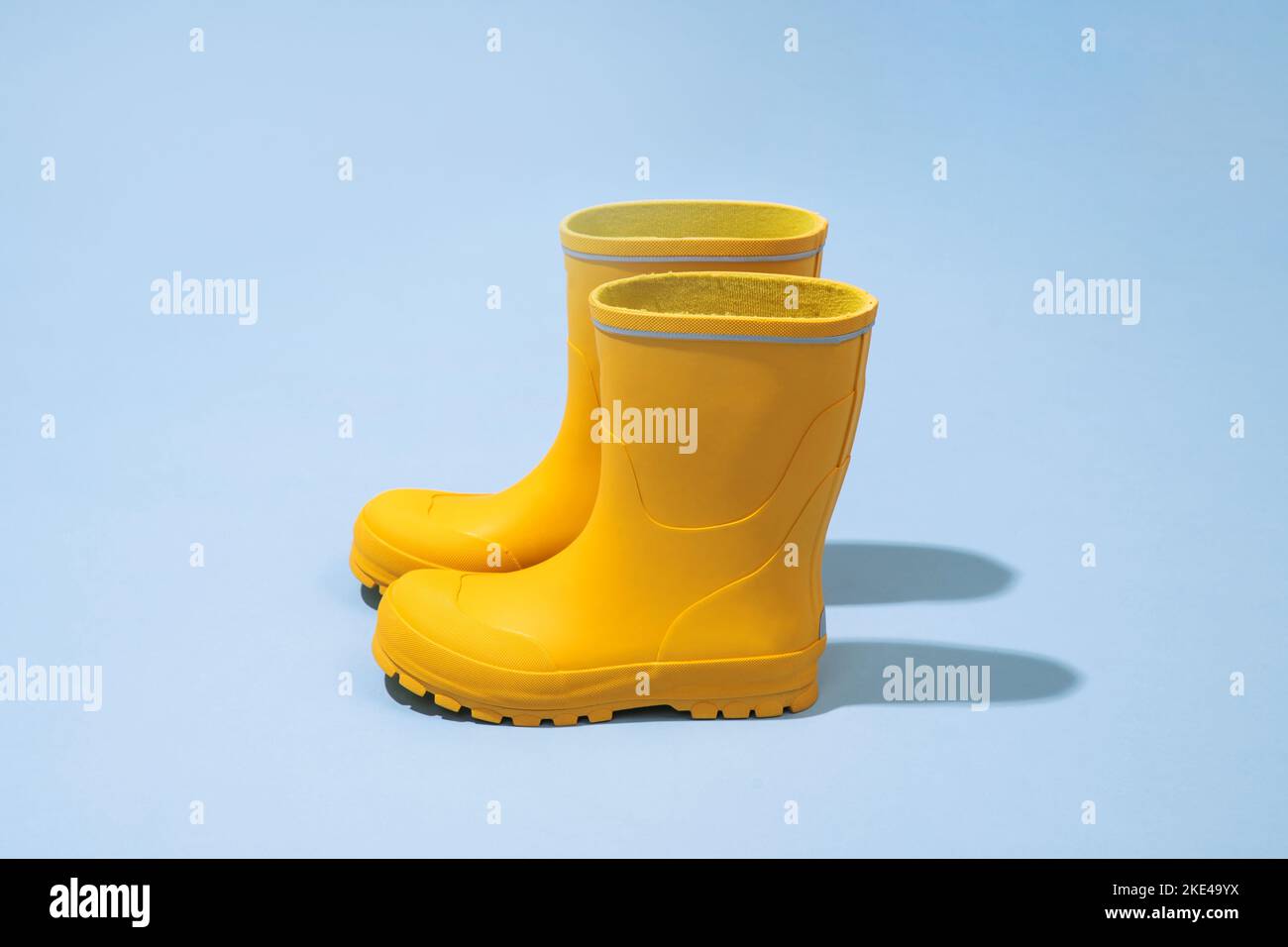 Yellow rubber boots isolated on blue background Stock Photo