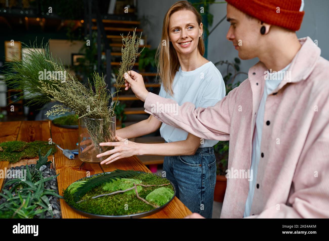 Two happy and smiling young florists working together at creative workshop Stock Photo