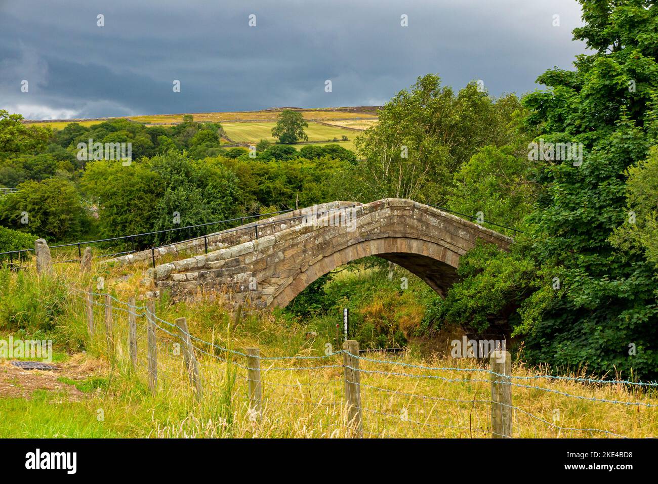 Duck Bridge near Danby in North Yorkshire England UK a post medieval packhorse bridge over the River Esk built of coursed herringbone sandstone. Stock Photo