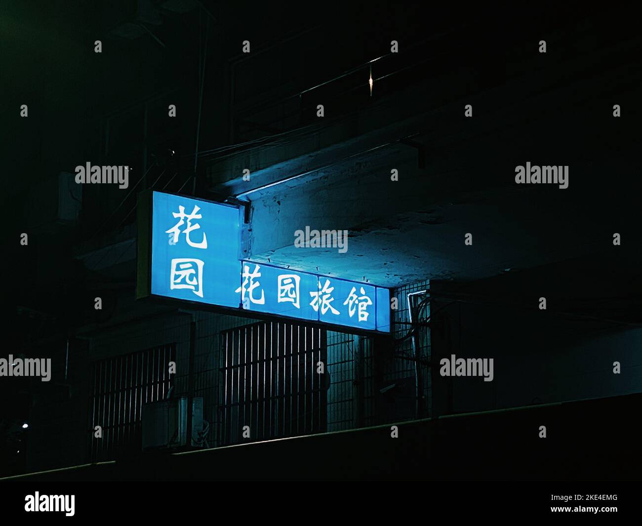 A blue sign on a building in Nanking, China at nighttime Stock Photo