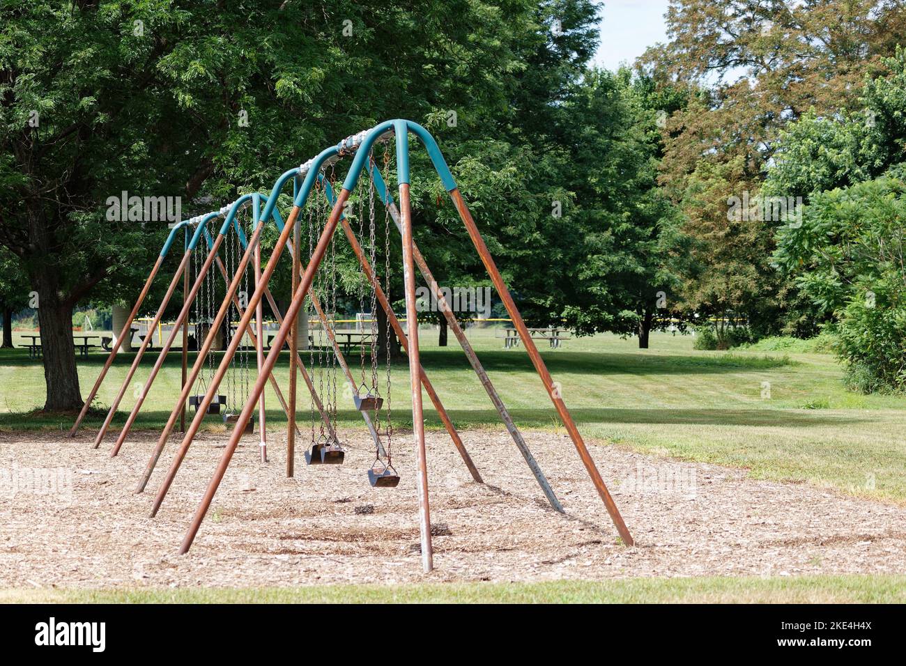 A Rusty Old Swing Set In A Green Lush Park Stock Photo Alamy