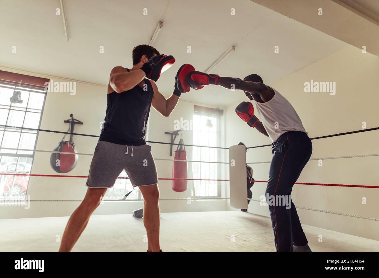 Fighter striking the focus mitts held by his personal trainer in a