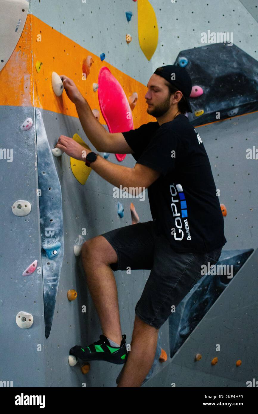 A handsome rockclimber male bouldering on colorful slopers on the