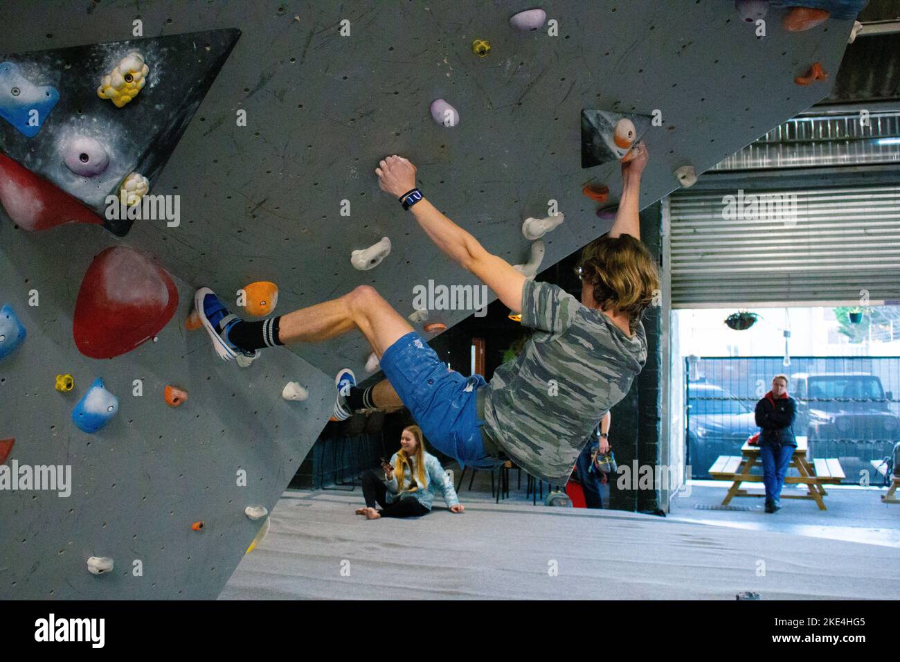 A handsome rockclimber male bouldering on colorful slopers on the