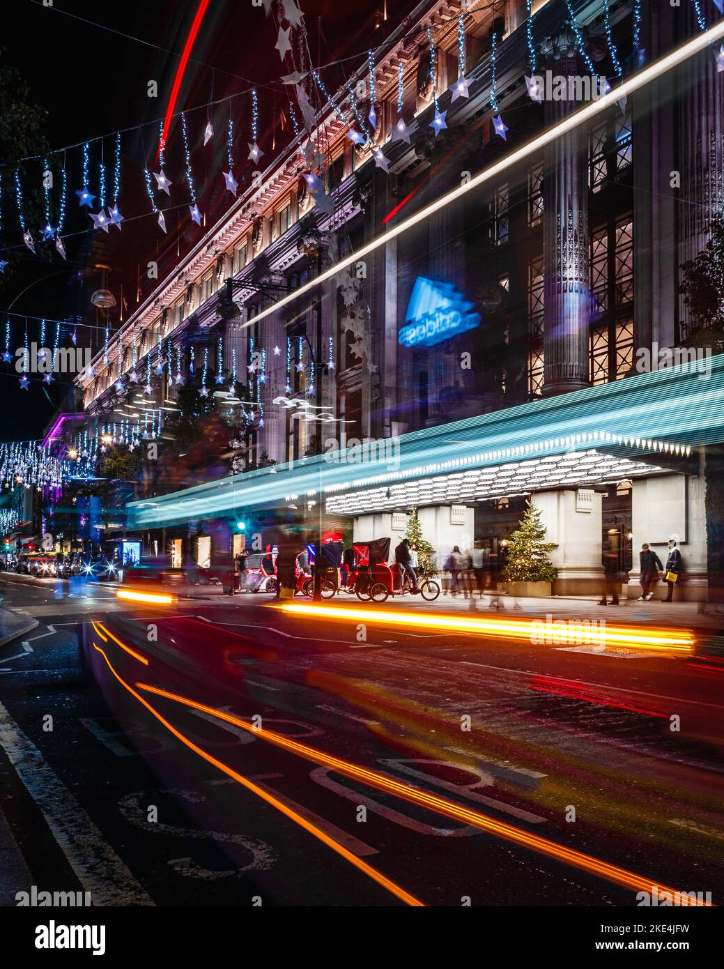 Light trails pass by Selfridge's in London under the Christmas lights