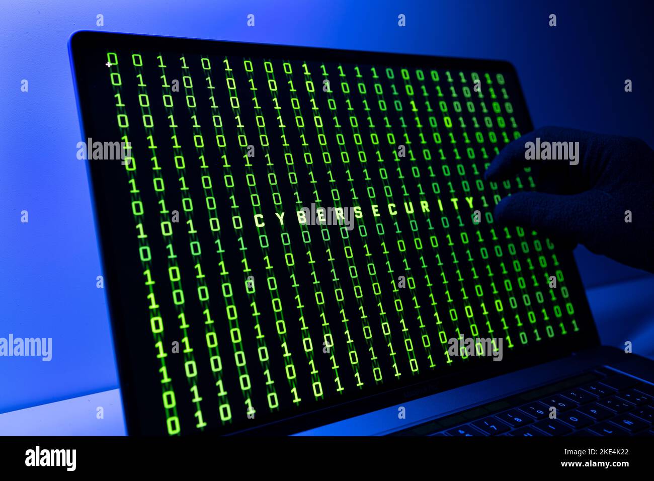 Ciber security concept. Gloved Hand, Binary code and cybersecurity word on laptop computer screen Stock Photo